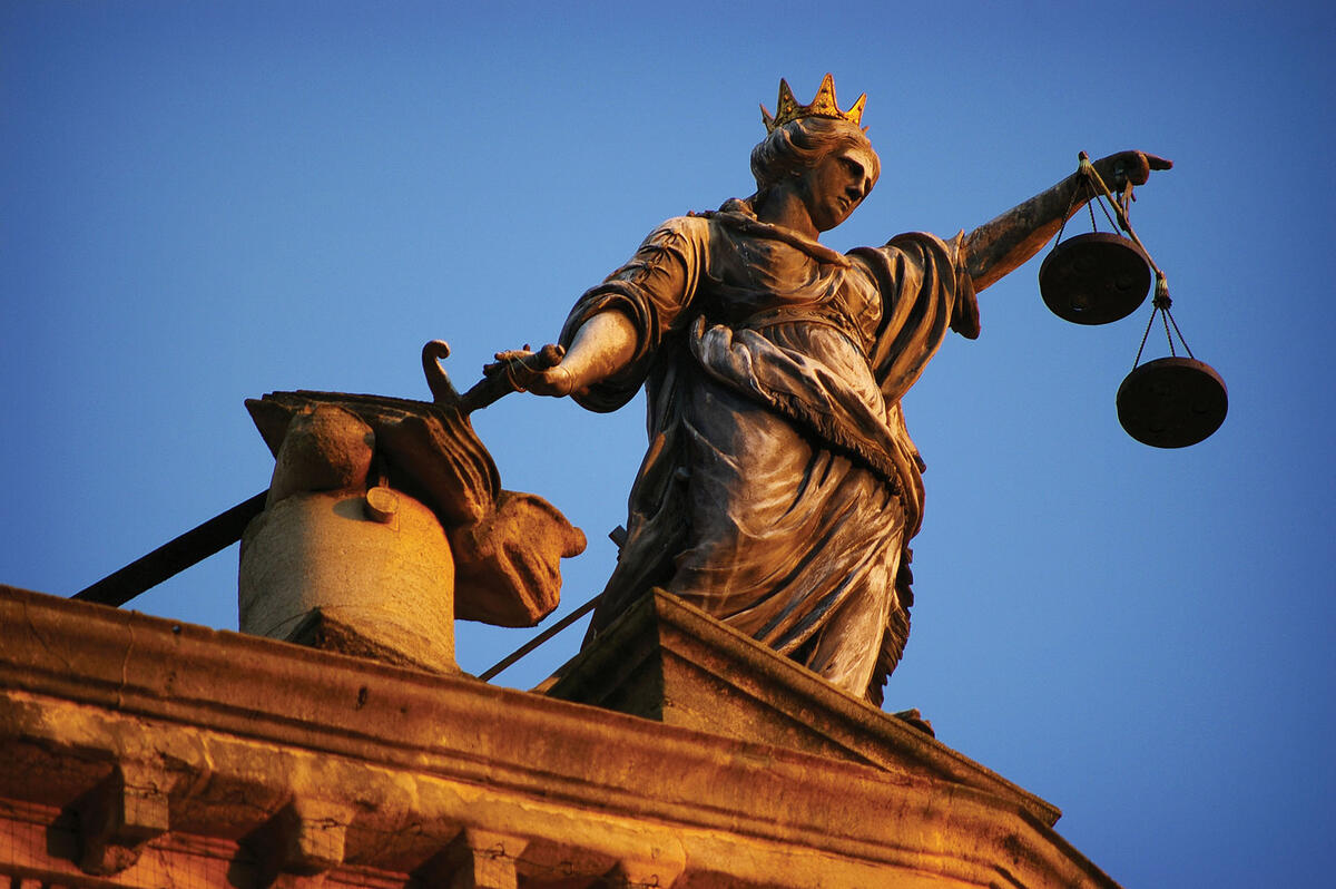 A statue of Justice holding her balanced scales and a sword. (Photo by Jesse Loughborough.)