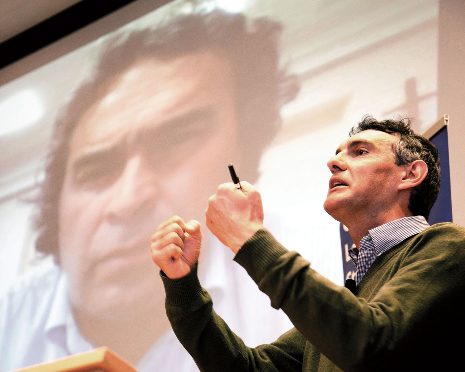 Emmanuel Saez speaks in Berkeley as Sergio Fajardo listens from Colombia. (Photo by Jim Block.) Emmanuel Saez speaks in Berkeley while, on a screen behind him, Sergio Fajardo listens from Colombia. (Photo by Jim Block.)