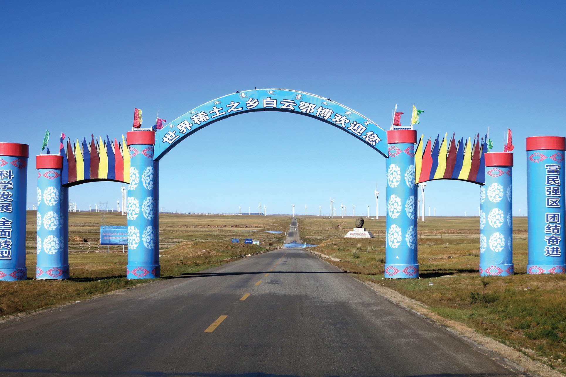 An archway above a road reads in Chinese, “Welcome to Bayan Obo, hometown of rare earths.” (Photo by Julie Klinger.)