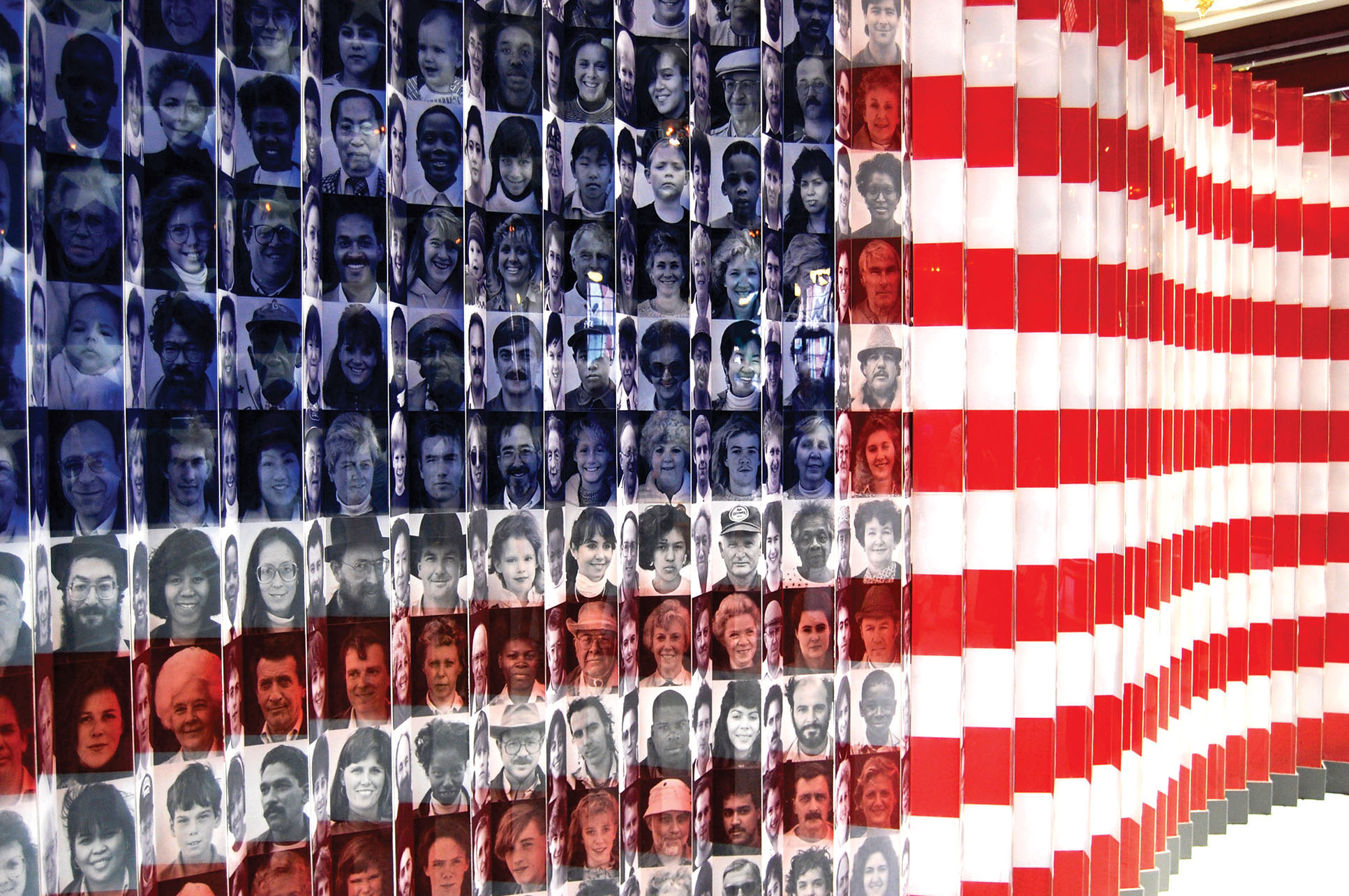 An  American flag with the faces of immigrants used to form part of the design on display at Ellis Island. (Photo by Ludovic Bertron.)