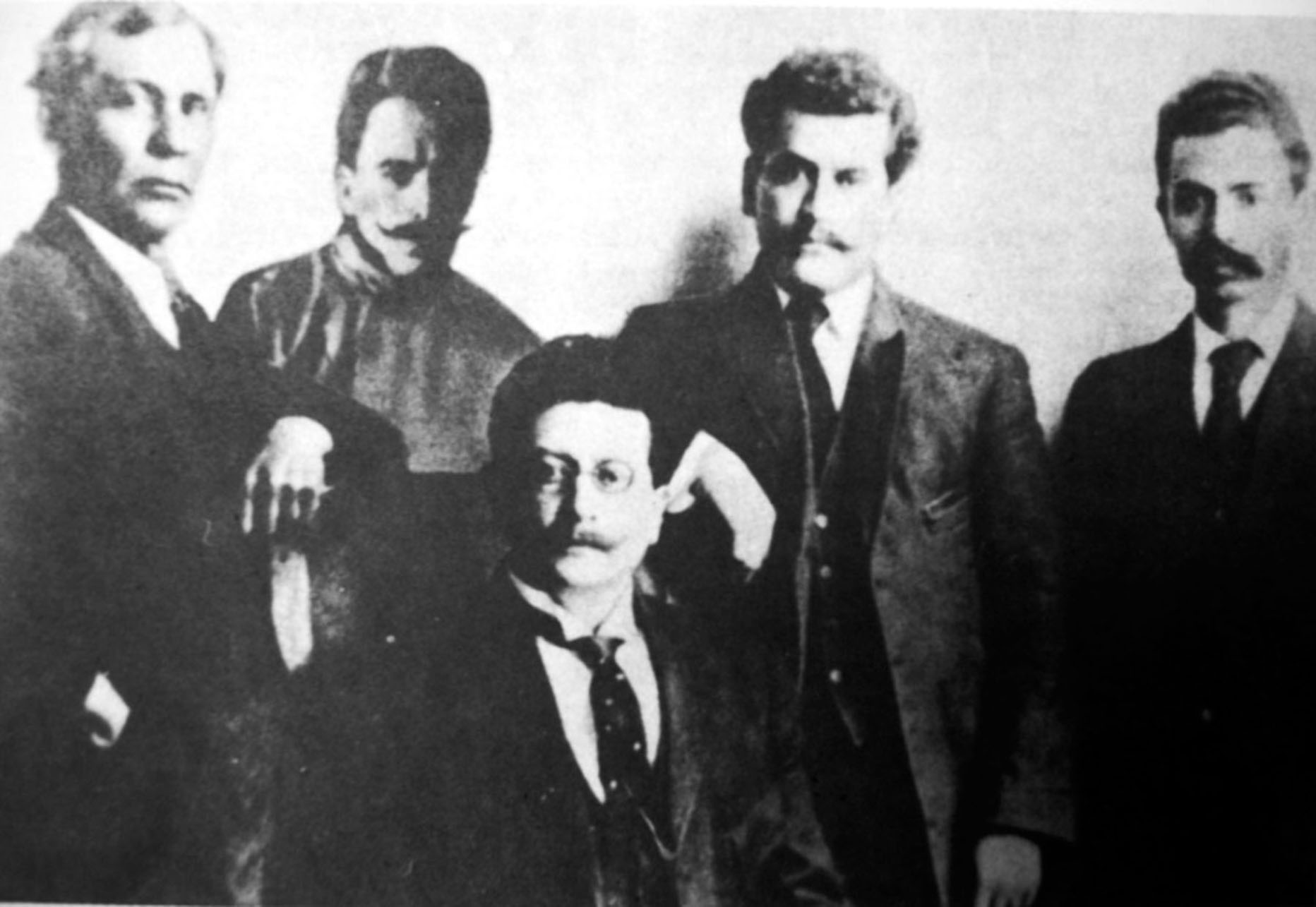 Black and white photo of members of the Junta Organizadora del Partido Liberal Mexicano in 1910. From left:  Anselmo Figueroa, Práxedis G. Guerrero, Ricardo Flores Magón, Enrique Flores Magón, and Librado Rivera. (Photo from Wikimedia Commons.) 