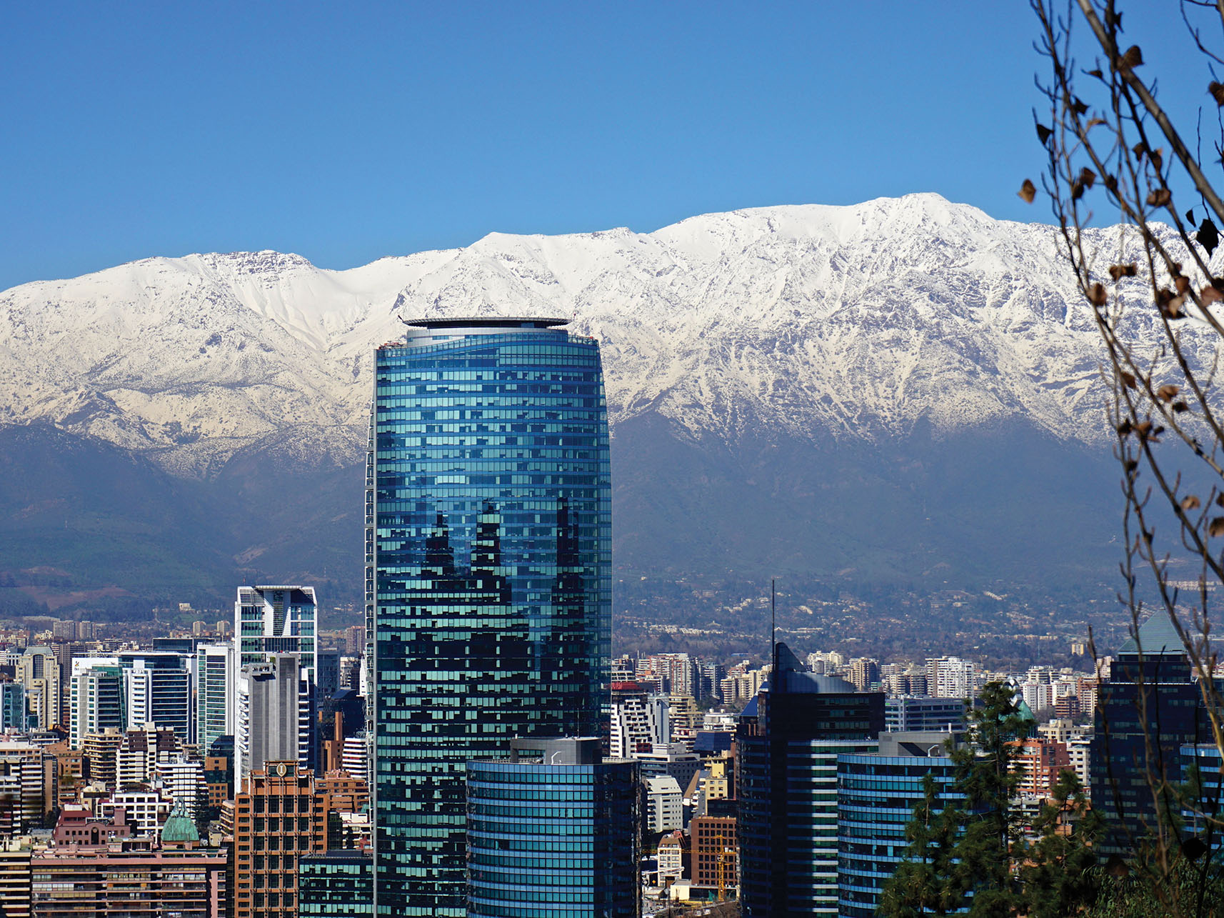 The Andes loom behind the modern buildings of the Santiago skyline. (Photo by alobos Life.)