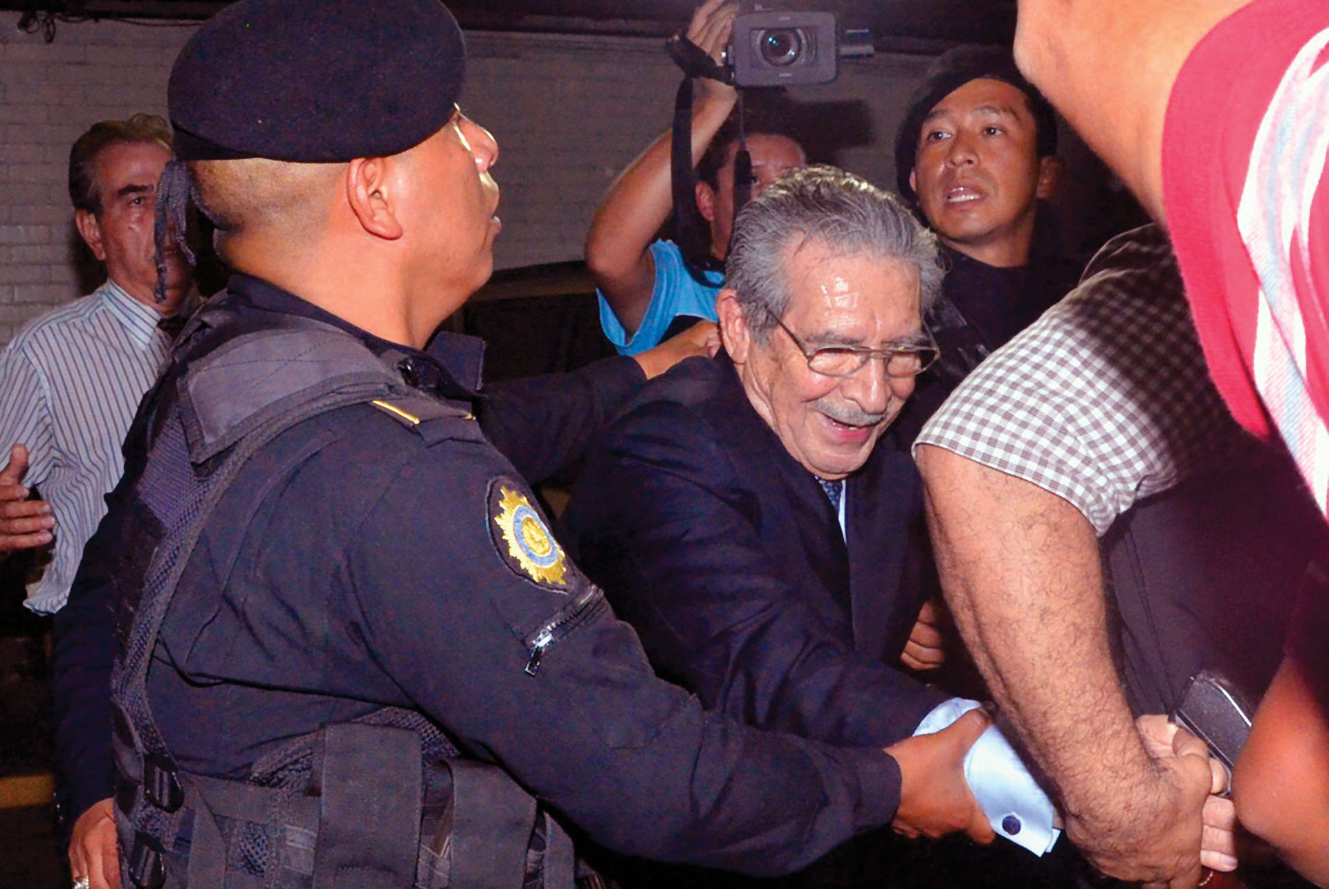 Former dictator Efraín Rios Montt is led away in handcuffs by Guatemalan police following his conviction. (Photo by José Anotnio Castro.)