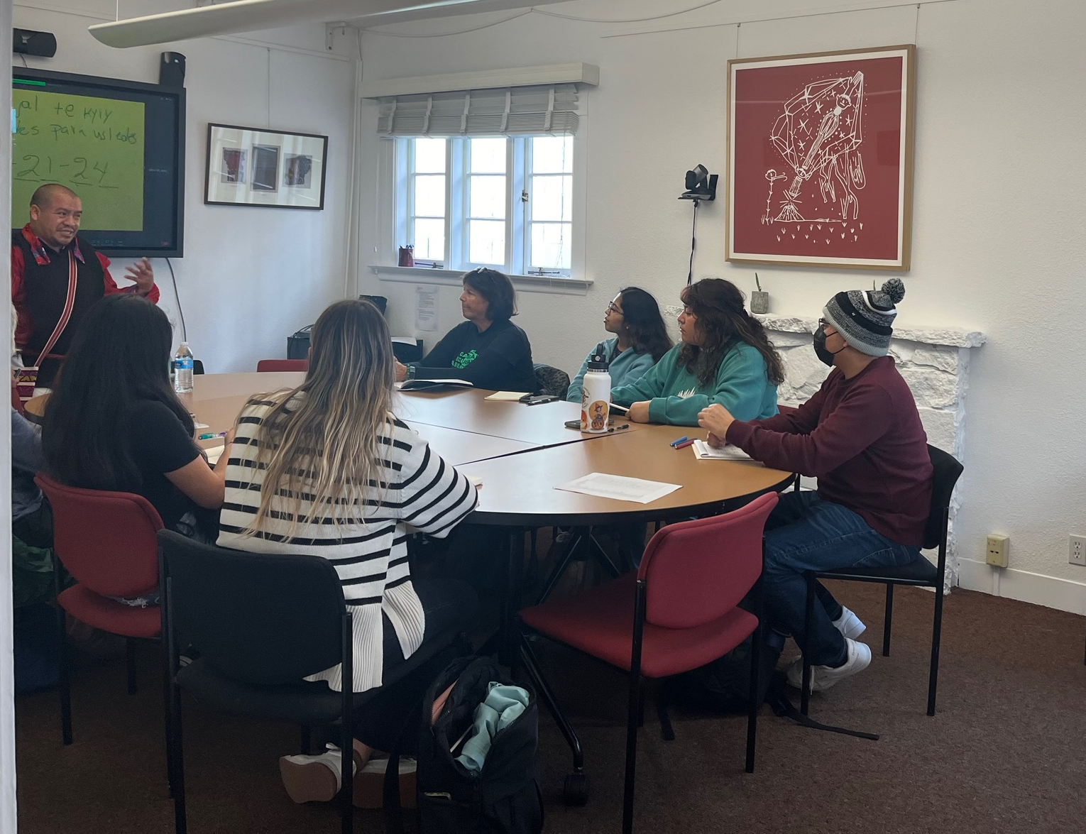 Students sitting at a table learning Mam from a teacher