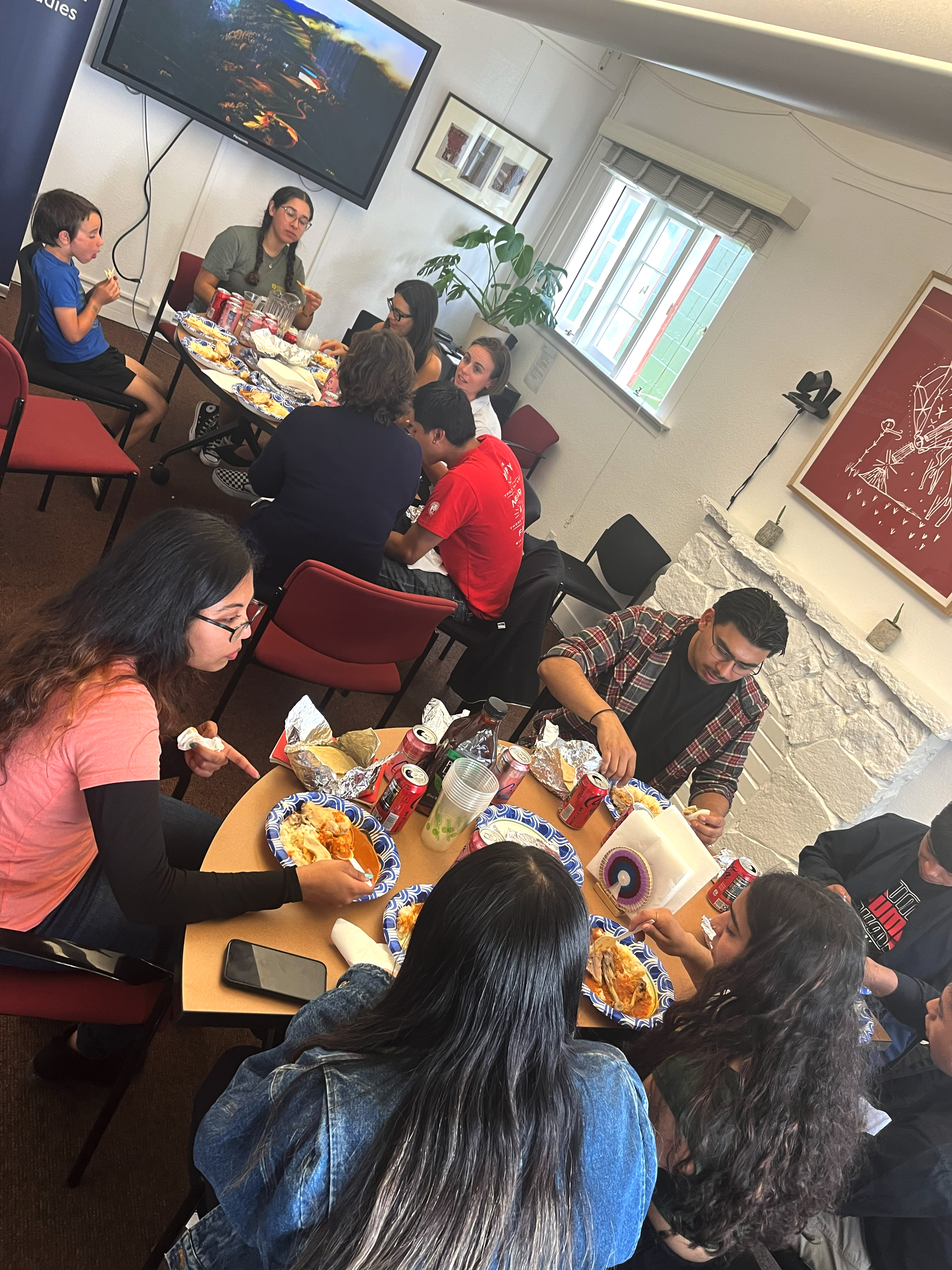 Mam students eating food at round tables