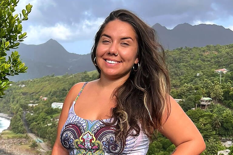 Portrait of Adriana Gonzales in a jungle-covered mountain landscape.