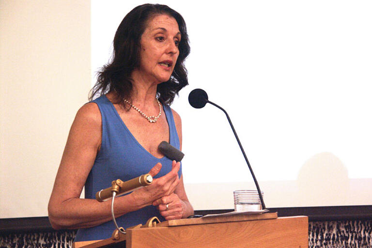 Claudia Bernardi speaking at UC Berkeley wearing a blue dress