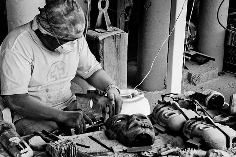A black and white photo of a worker making masks in Teotihuacán