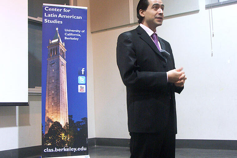 Roberto Hernández wearing a black suit, standing up talking about his documentary 