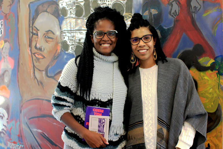 Djamila Ribeiro (right) of the Movimento de Feministas Negras, standing up 