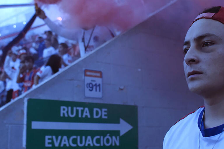 A young man in the entrance to a soccer stadium. Image from 90 Minutos. (Image courtesy of Pulsar.)