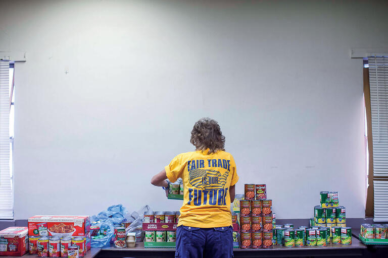 A former steel mill employee in front of a table of canned goods in a union-sponsored food bank in Granite City, Illinois. (Photo by Whitney Curtis for The New York Times.)