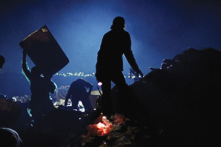 The catadores work with headlights of dumptrucks for illumination through the night. (Film still courtesy of Almega Projects and O2 Filmes.)