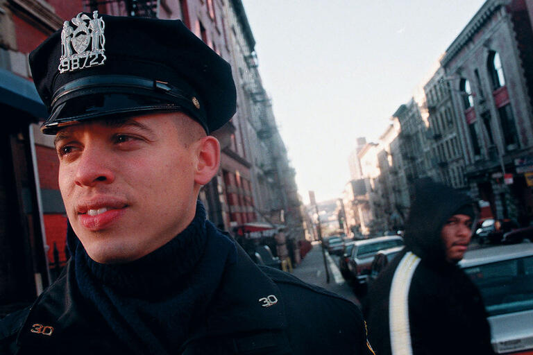 A uniformed officer patrols New York’s Washington Heights neighborhood, 1998. (Photo by Mark Lennihan, Associated Press.)