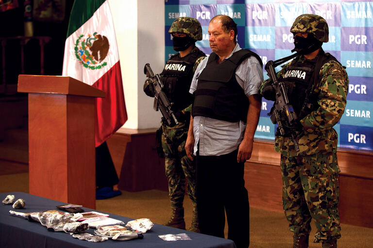 Mexican naval forces show off the captured Mario Cárdenas Guillén, alleged leader of the Gulf cartel, at a press conference in 2012. (Photo by Yuri Cortez/AFP/Getty Images.)