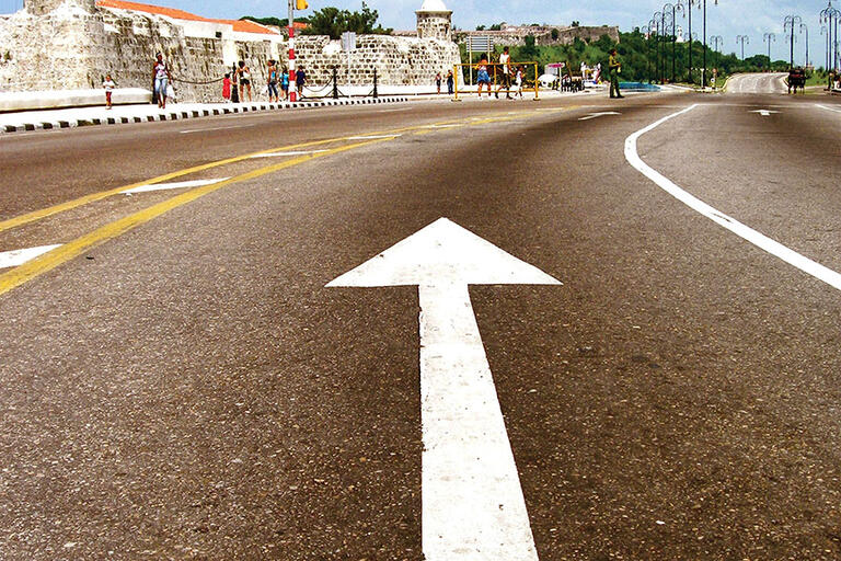 An arrow points along a road next to an old fortress in Havana, Cuba. (Photo by Ana García.)