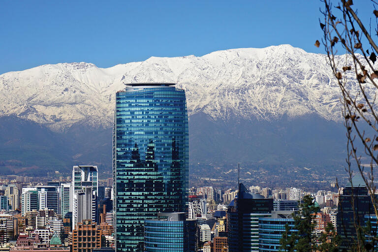 The Andes loom behind the modern buildings of the Santiago skyline. (Photo by alobos Life.)