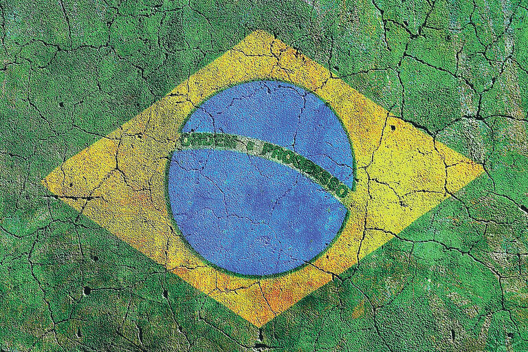 A Brazilian flag painted on a pitted and cracked sidewalk. (Photo by AKRockefeller.)