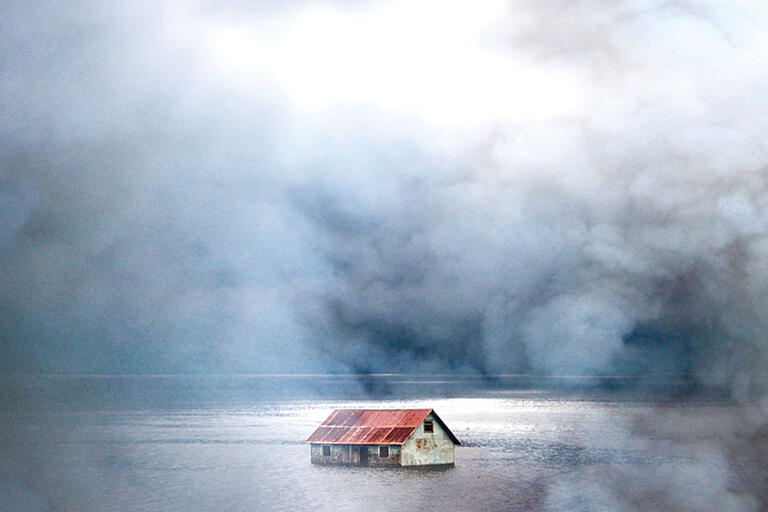 A house on Chiloé sits out in the water and fog. (Photo by Carles Cerulla.)