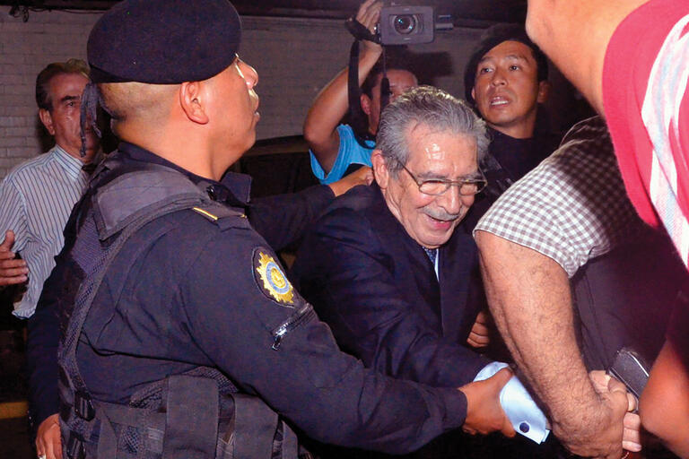 Former dictator Efraín Rios Montt is led away in handcuffs by Guatemalan police following his conviction. (Photo by José Anotnio Castro.)