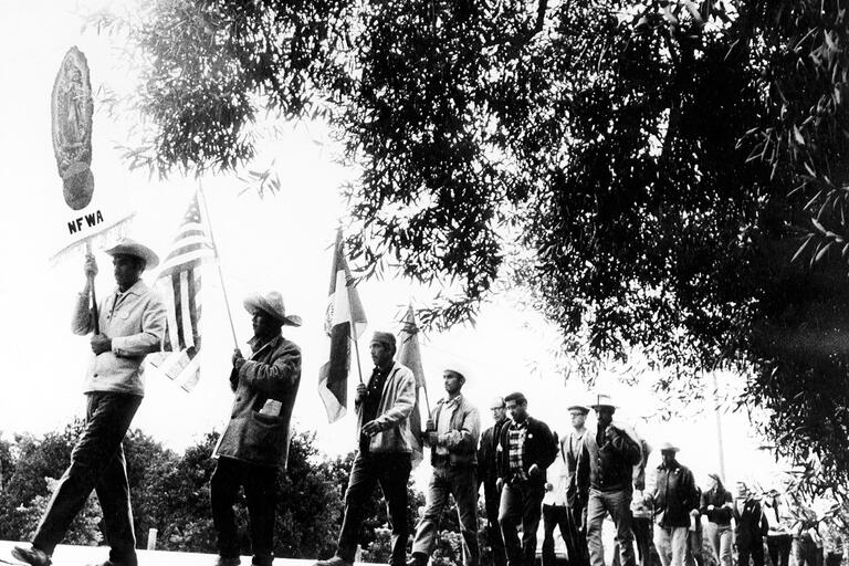 A line of farm workers and supporters with signs and UFW flags march along the road from Delano to Sacramento, 1968. (Photo: Walter P. Reuther Library, Archives of Labor and Union Affairs, Wayne State University.)