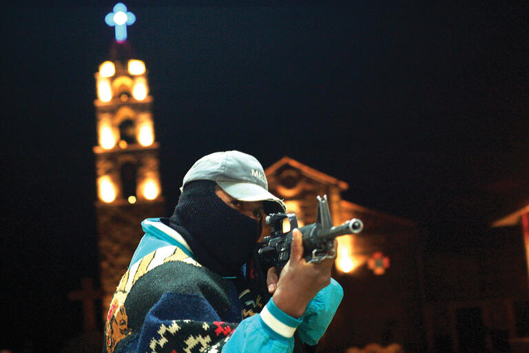 A member of the community guard of Turícuaro, Michoacán shows off by aiming his assault rifle. (Photo by Juan José Estrada Serafín.)