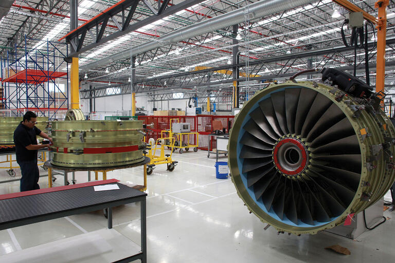 The work floor of an aircraft service center in Querétaro, with a disassembled jet engine. (Photo by francediplomatie.)