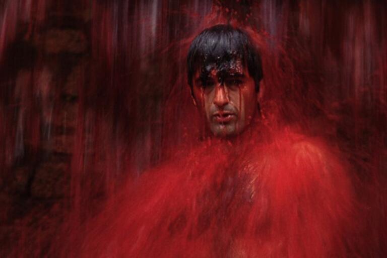 A man takes a red shower.
