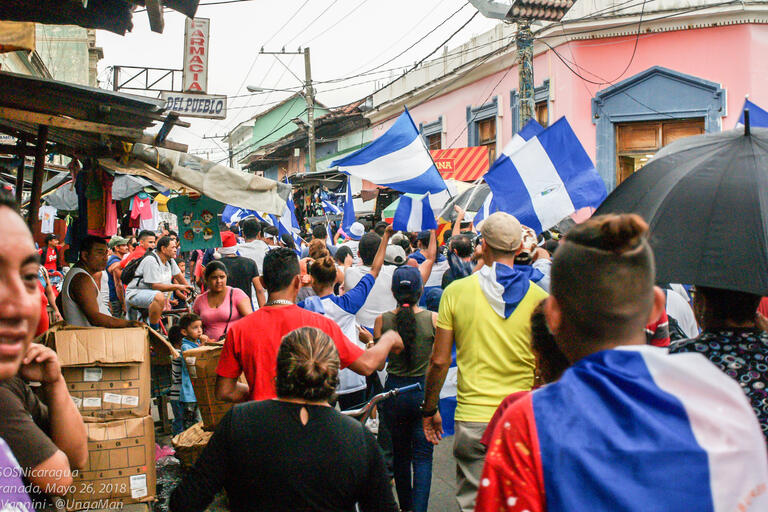 Protesters walking together in the street with Nicaraguan flags