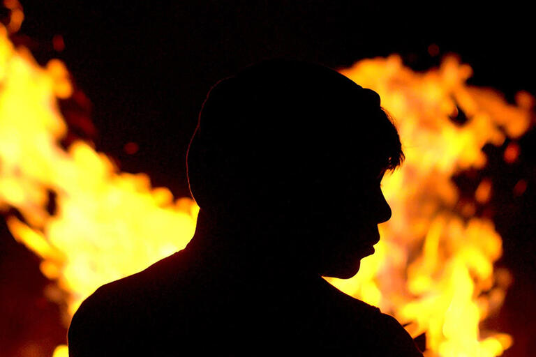 Kid’s silhouette against fire 