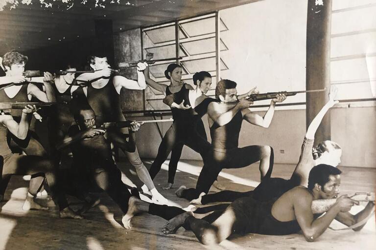 Black and white image of dancers with guns