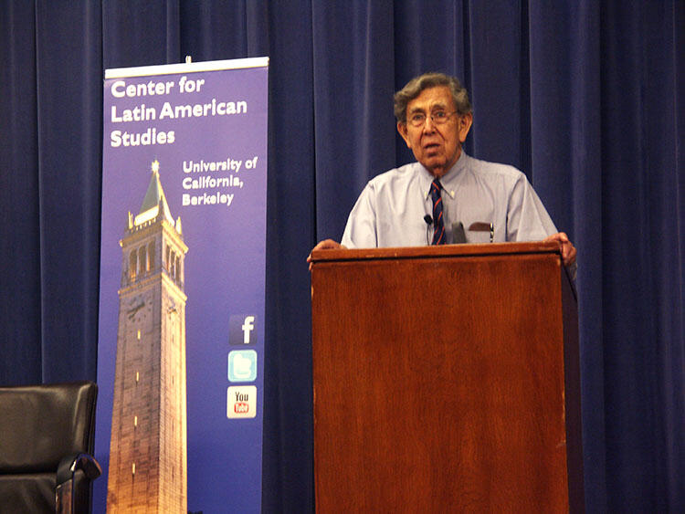 Cuauhtémoc Cárdenas speaking at UC Berkeley, standing in front of a CLAS banner