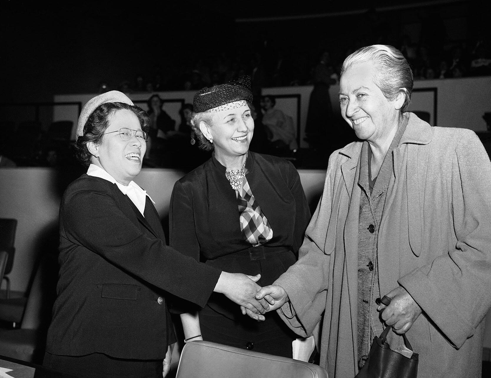 Black and white photo of Gabriela Mistral (right) greeting other attendees at a meeting of the U.N. Commission on the Status of Women in New York, March 1953. (Photo by John Rooney/AP Photo.)
