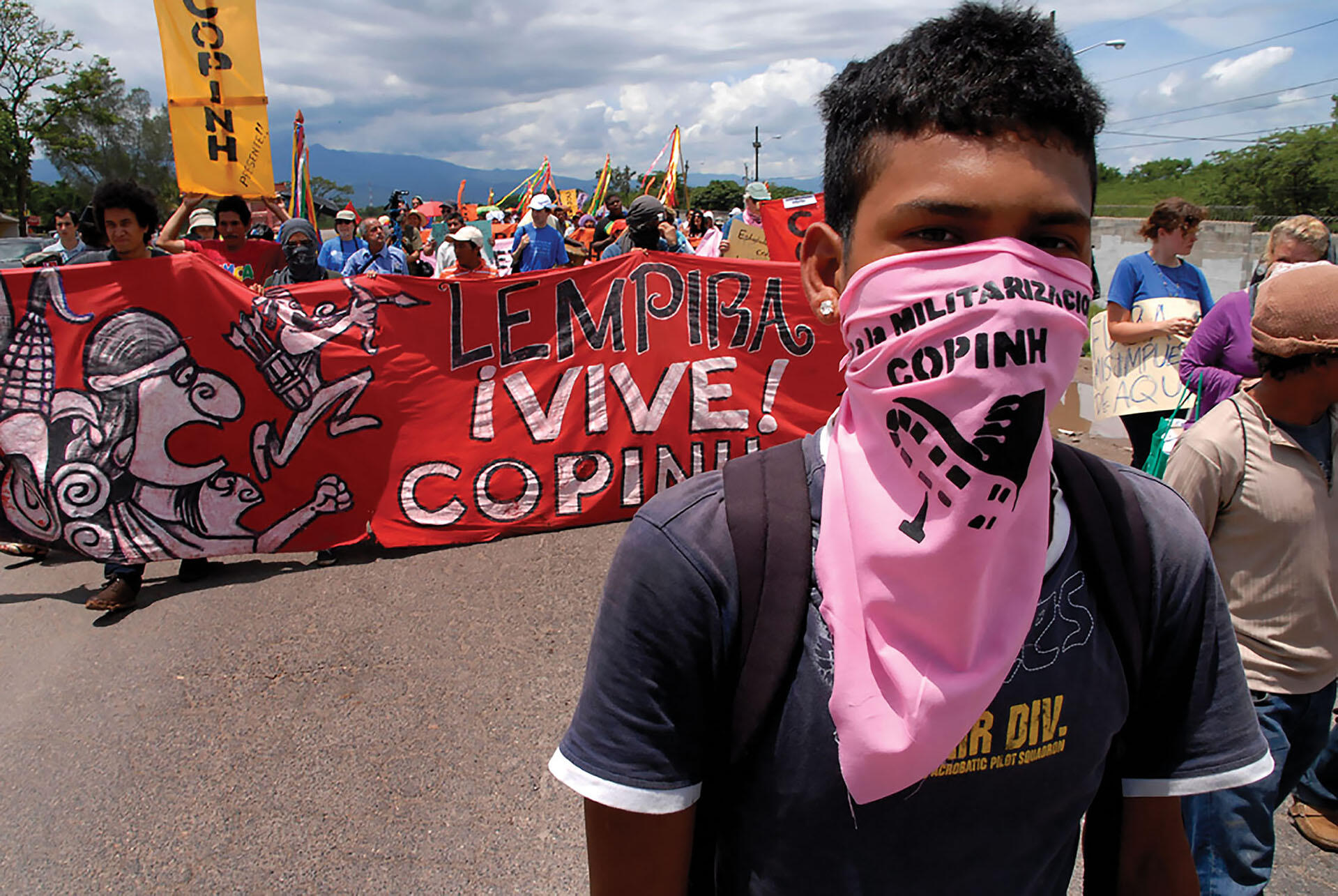A COPINH protestor wearing a pink bandana as a mask marches in a protest against U.S. military bases in Honduras. (Photo by Felipe Canova.)