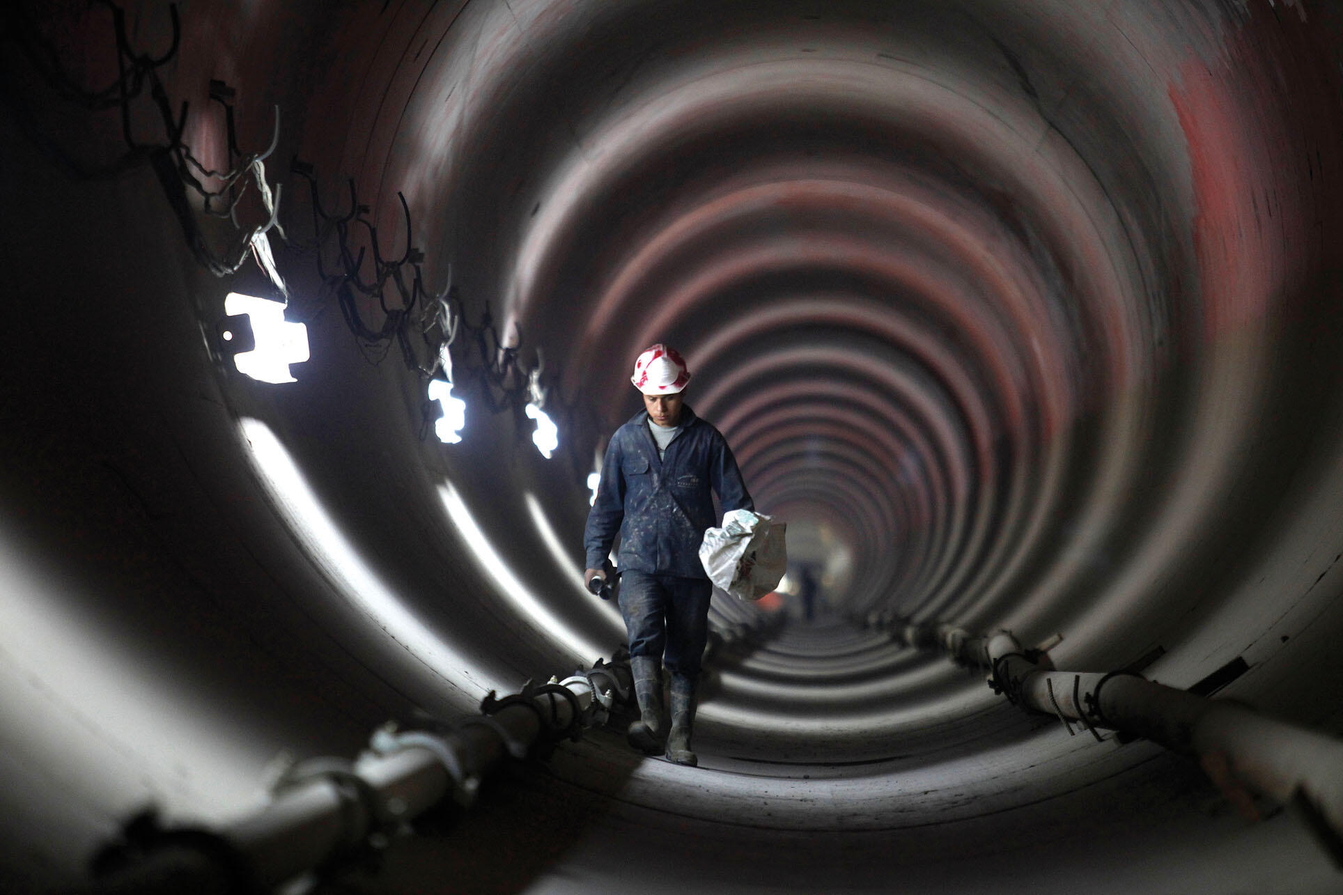 A worker inside one of the tunnels that make up Mexico City’s deep-drainage system. (Photo by Dario Lopez-Mills/Associated Press.)