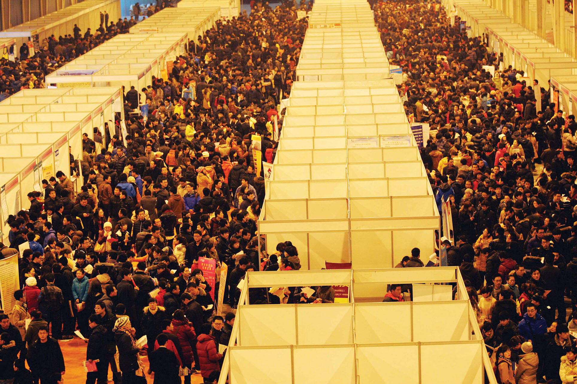 Crowds throng the booths at a job fair in Weifang, China, February 2012. (Photo by Zhang chi sd – Imaginechina/Associated Press.)