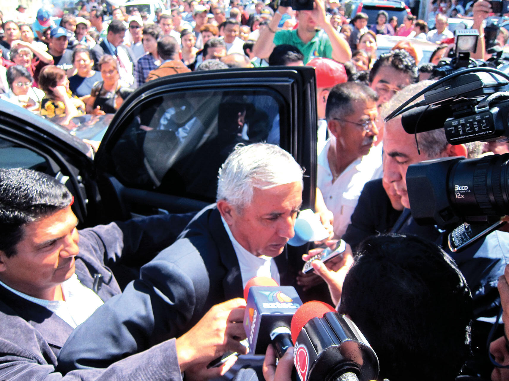 Otto Pérez Molina exiting a car in a crowd on election day. (Photo by Anthony Fontes.)