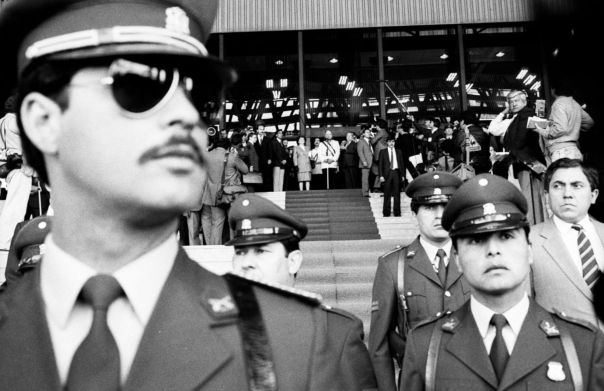 Guards in sunglasses protect Pinochet, standing at the podium at the top of stairs during a 1988 rally. (Photo by Marcelo Montecino.)
