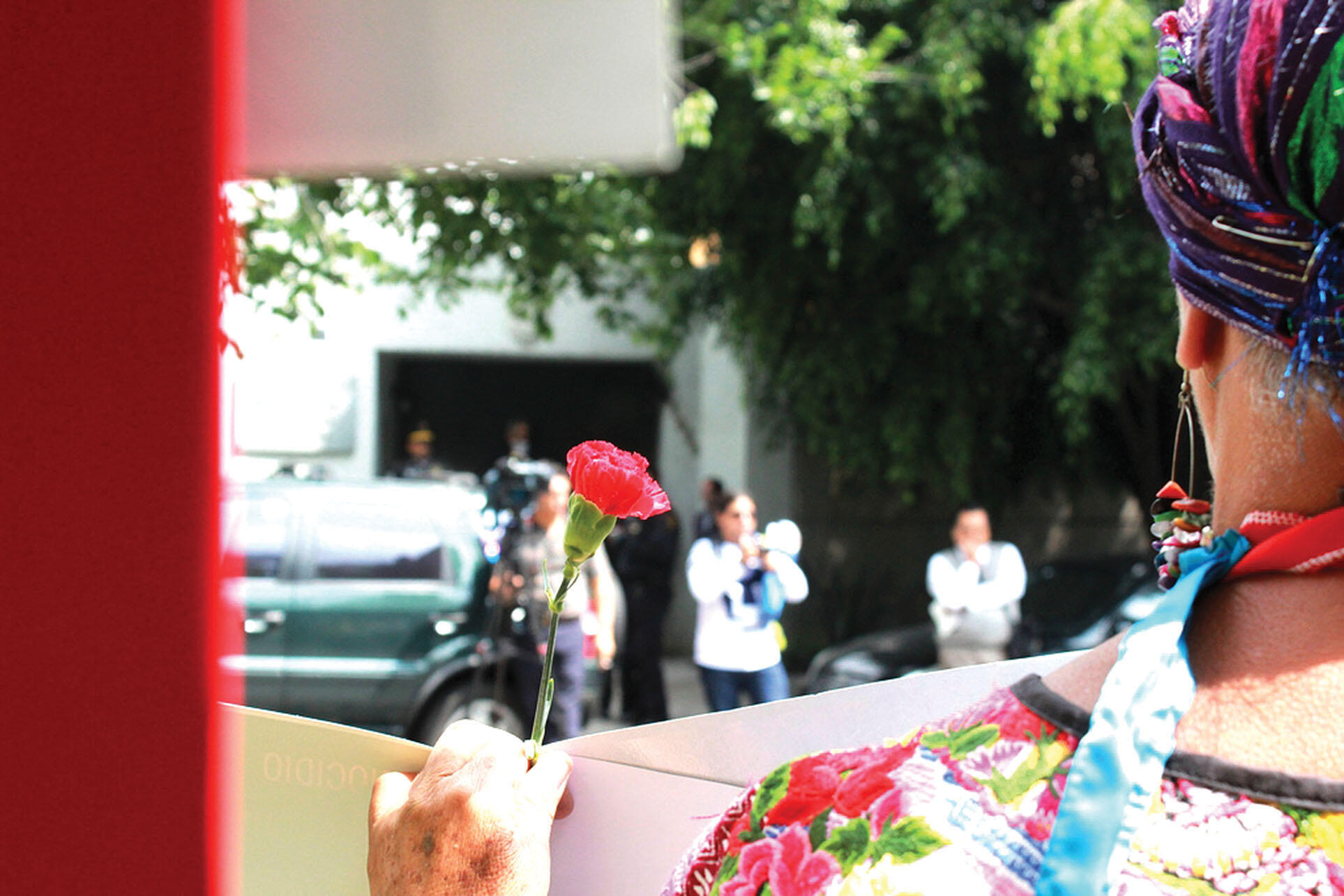 A woman holding a flower protests the annulment of Ríos Montt’s conviction. (Photo courtesy of Amnistía México.)