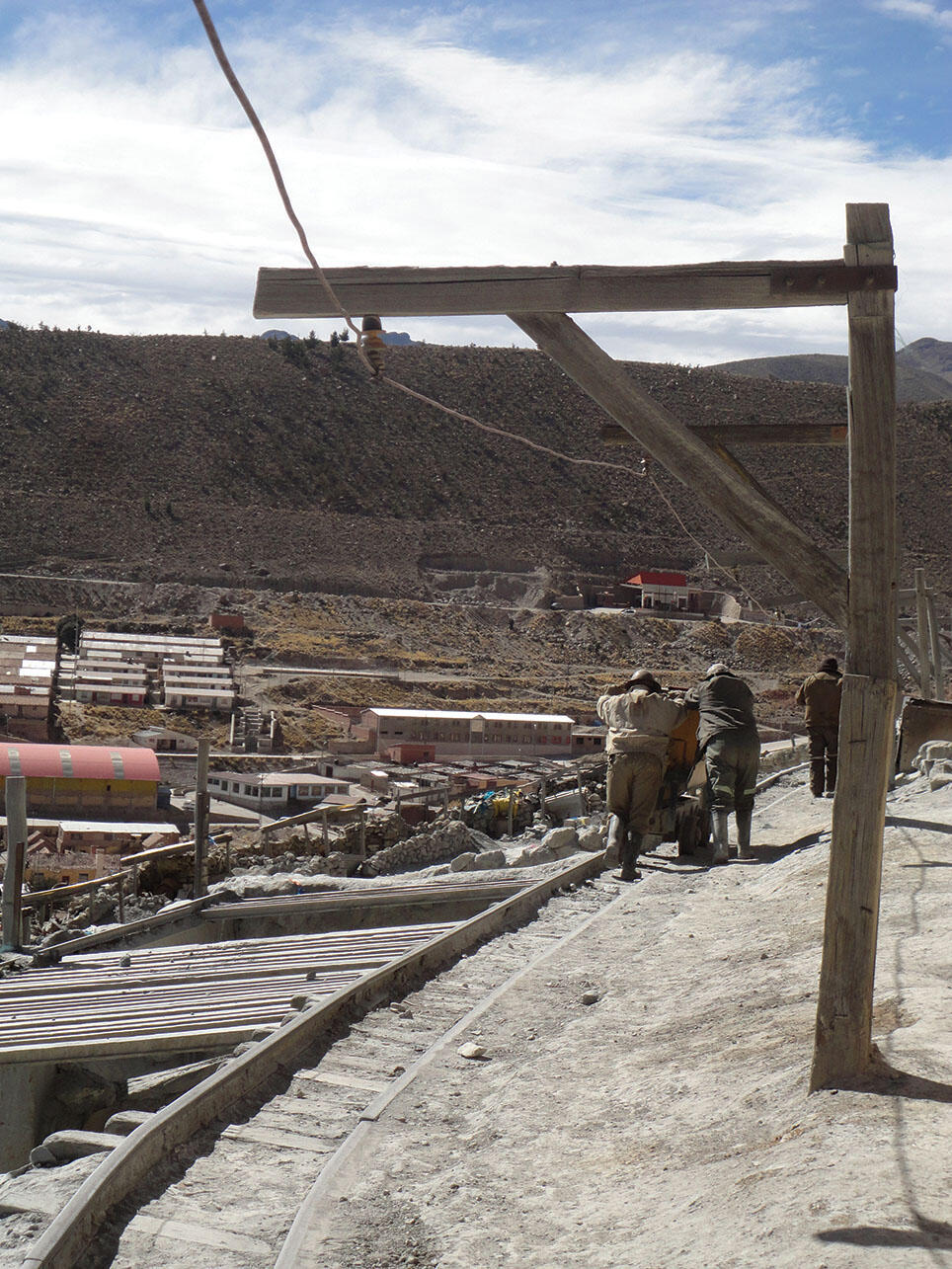 Two miners push a handcart full of minerals along the tracks in Potosí. (Photo by Andrea Marston.)