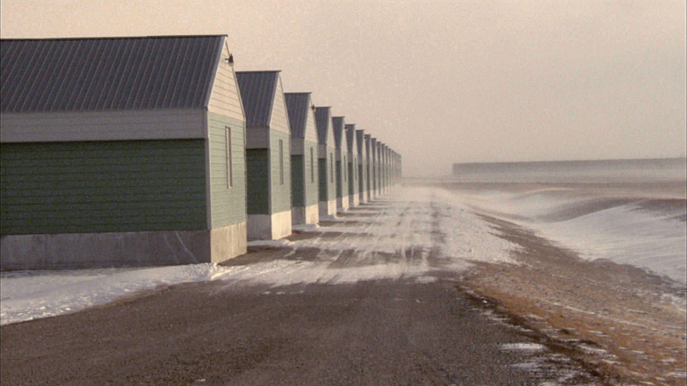 Rows of henhouses in winter at an Iowa chicken farm where female workers alleged rampant sexual abuse. (Photo by Vicente Franco.)