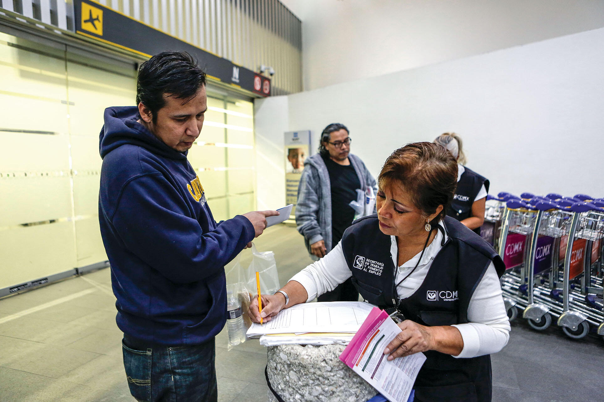 An employee of Mexico City’s Department of Labor takes information to help a recently returned deportee find a job. (Photo by Ginette Riquelme.)