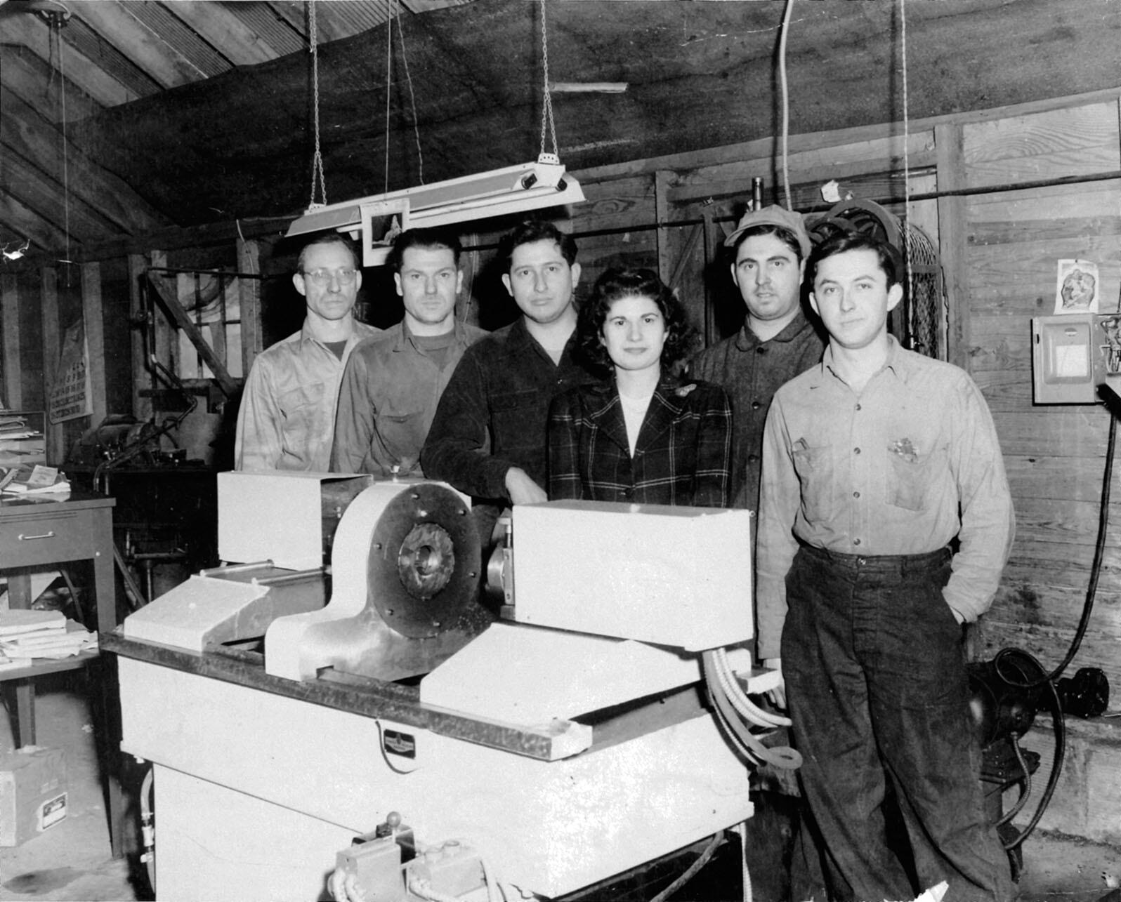In a converted barn, Stan Ovshinsky (third from left) and his crew pose with his newly invented Benjamin Automatic Lathe in 1946. (Photo courtesy of Lillian Hoddeson and Peter Garrett.)