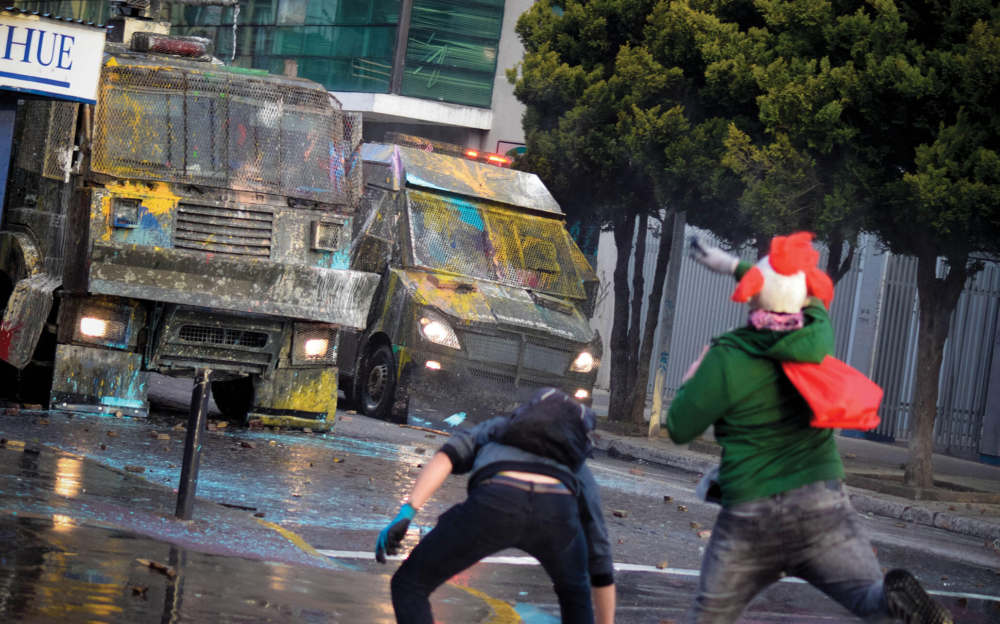Demonstrators throw paint at police vehicles in Santiago, November 2019. (Photo by cameramemories.)