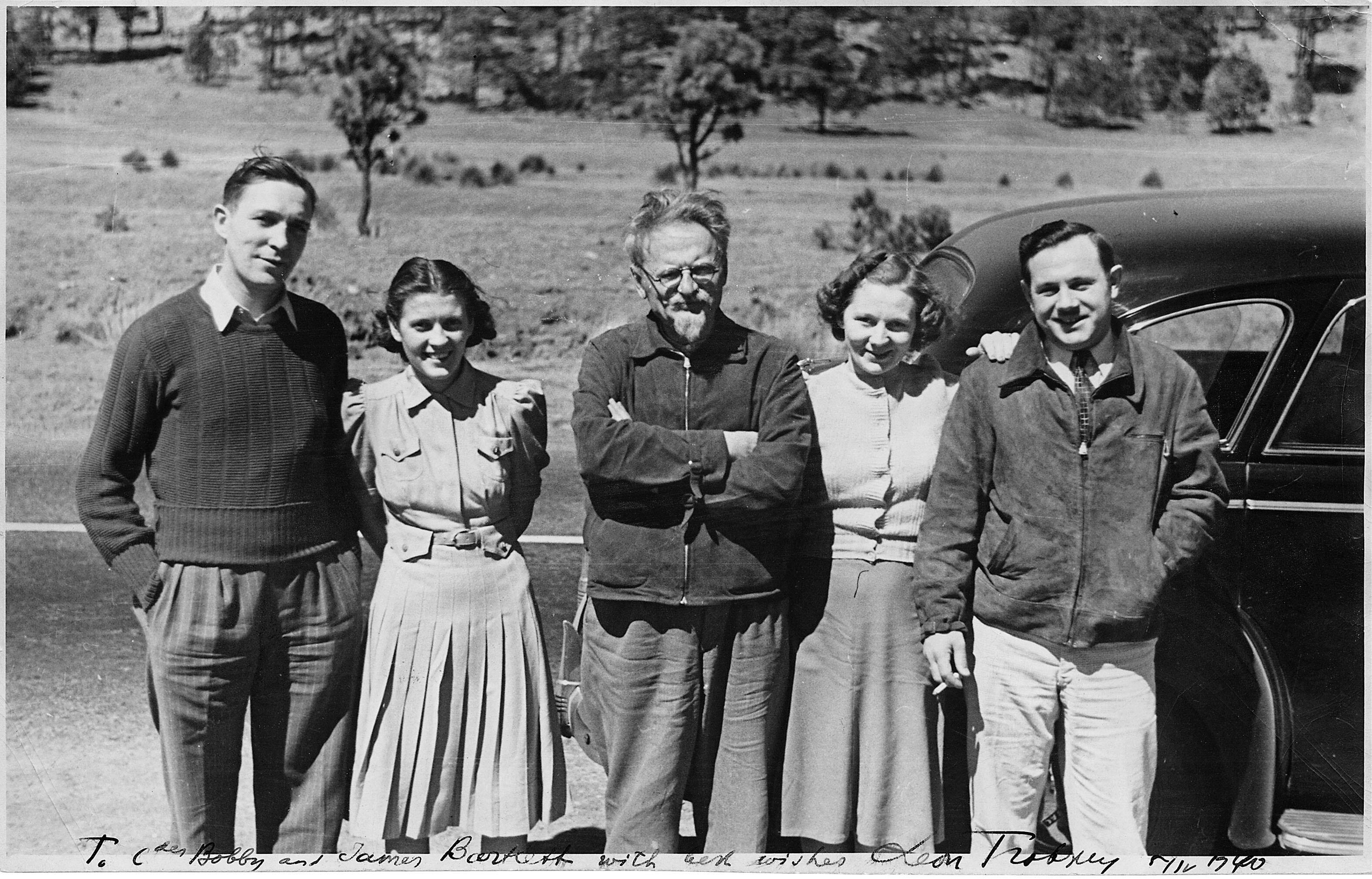 Trotsky poses on the side of a road in front of a car with American Trotskyites, April 1940. (Photo courtesy of The National Archives.)