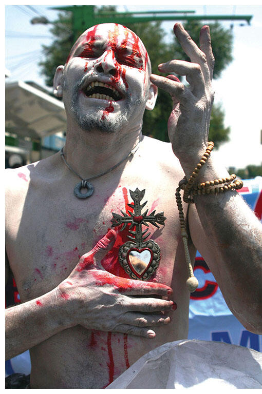 A demonstrator covered in fake blood with a Christian "sacred heart of Jesus" icon at the May 8, 2011 march in Mexico City. (Photo by Xareni Guzmán.)