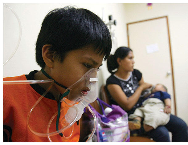 A Peruvian boy wears an oxygen mask as he receives asthma treatment in Lima, a city rated among the most polluted in Latin America. (Photo by Martin Mejia/Associated Press.)