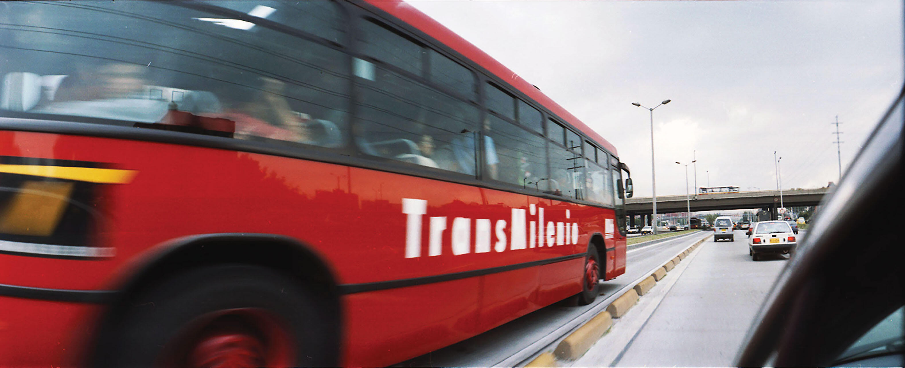 A red bus of Bogota’s Transmilenio speeds by. (Photo by Juan Felipe Rubio.)