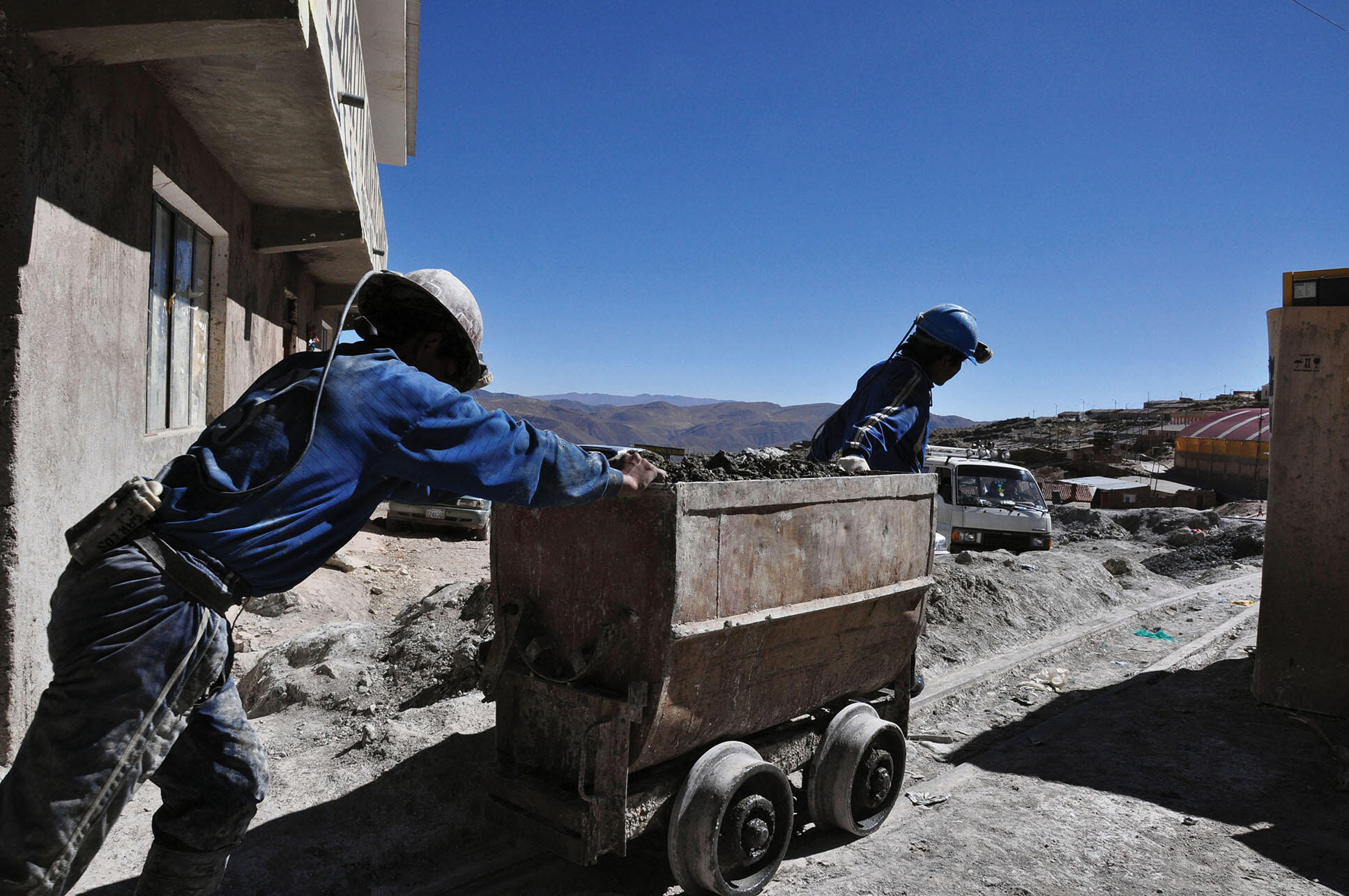 With an economy heavily based on extraction, Bolivian miners pushing carts out of the mines in Potosí, Bolivia. (Photo by Nyall & Maryanne.)