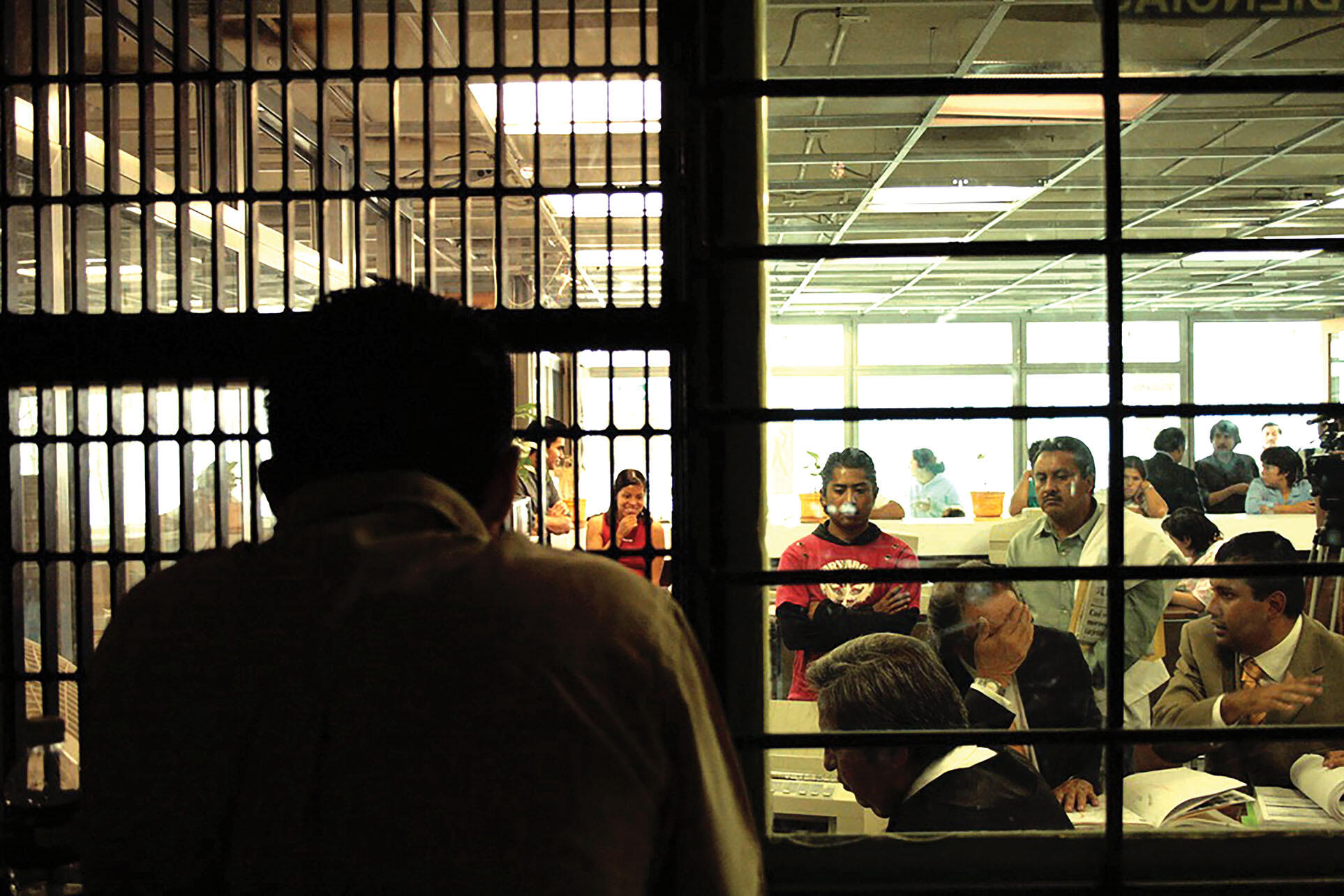 Toño Zúñiga stands behind bars in an old-style courtroom. (Photo courtesy of Layda Negrete and Roberto Hernández.)